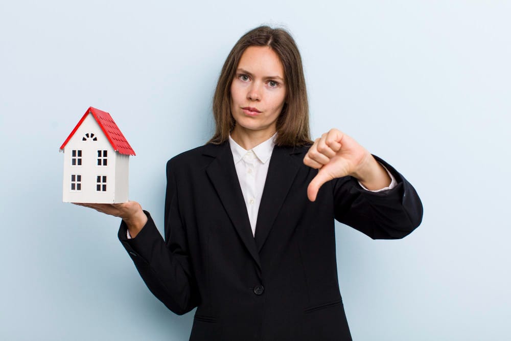 donna con casa in mano dice di no con la mano